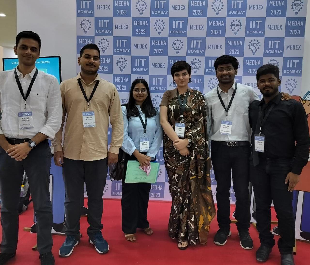 Six members of the winning team standing in front of an IIT Bombay MEDEX 2023 and MEDHA 2023 backdrop