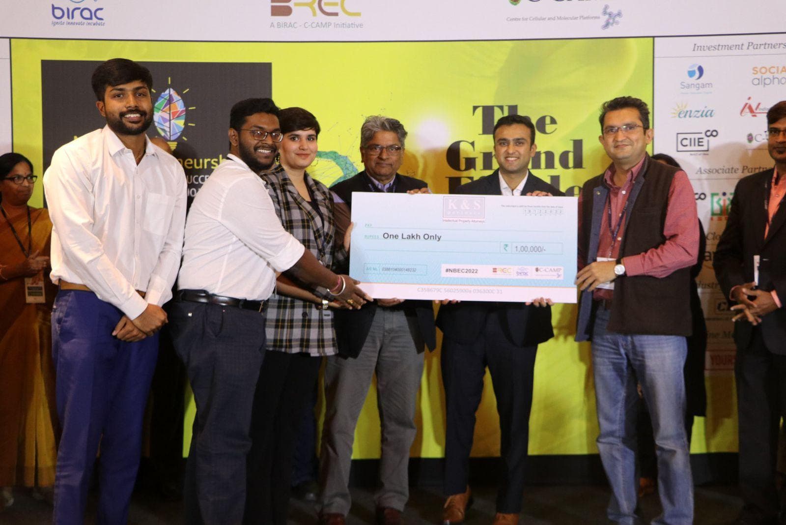 Winning team on stage receiving a large presentation cheque