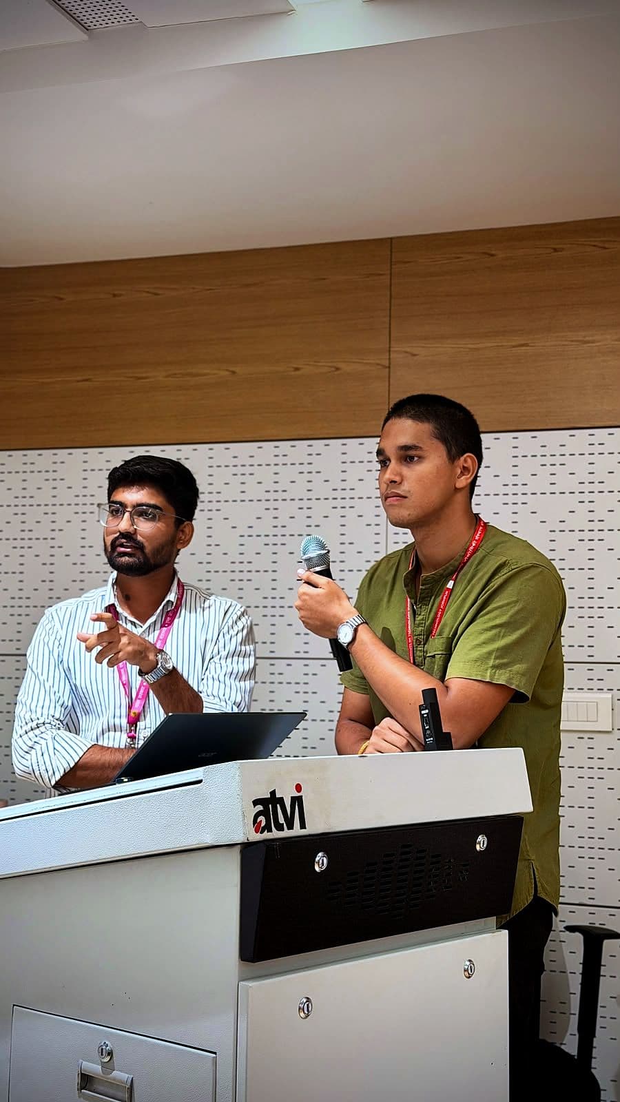 Two presenters at a lectern during a startup pitch session