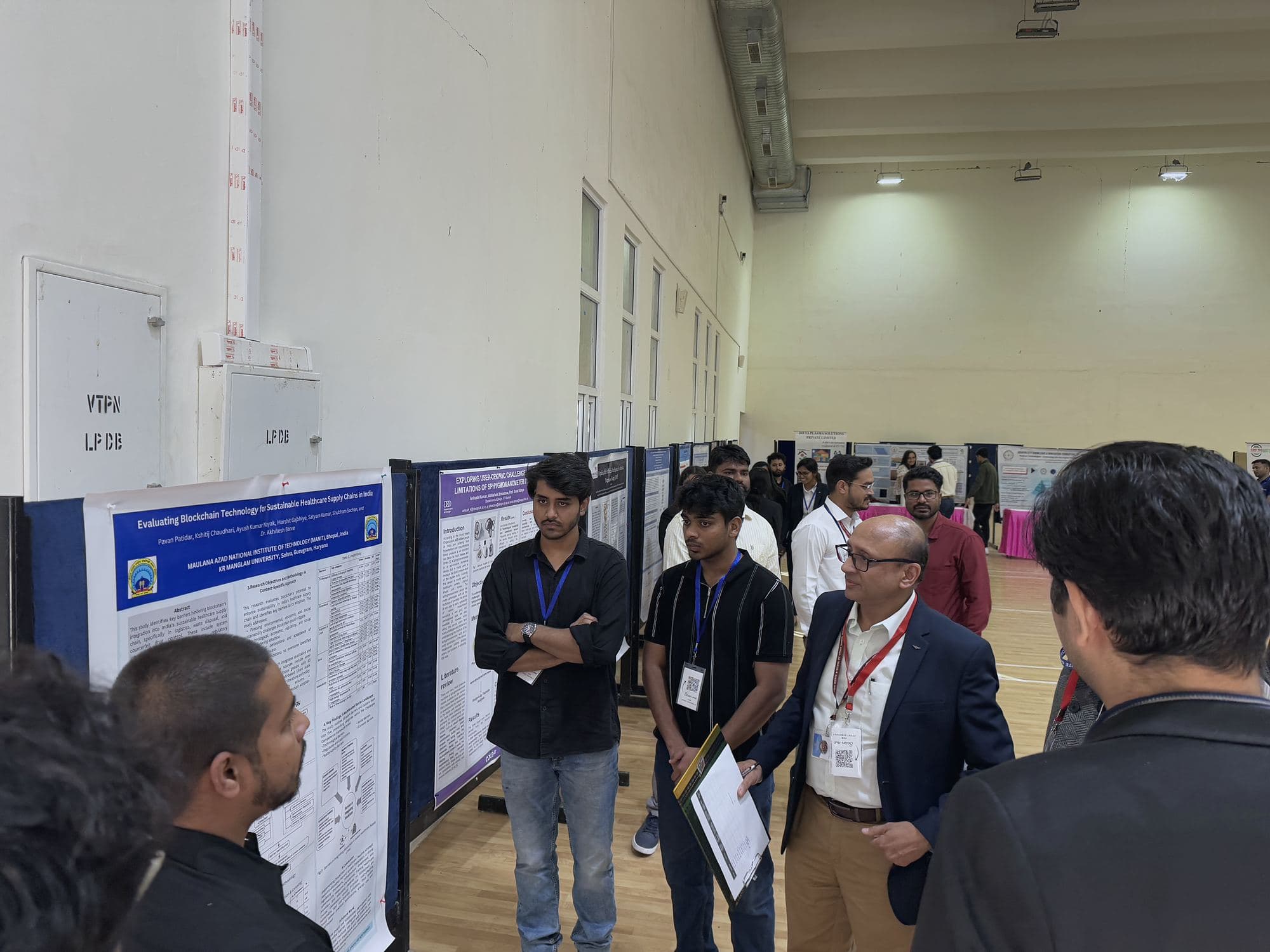 Students discussing research posters with a delegate during the poster session