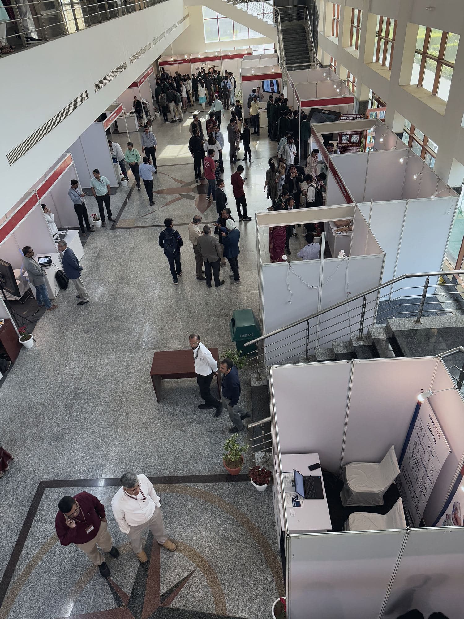 Overhead view of visitors moving between exhibition booths in a long hall
