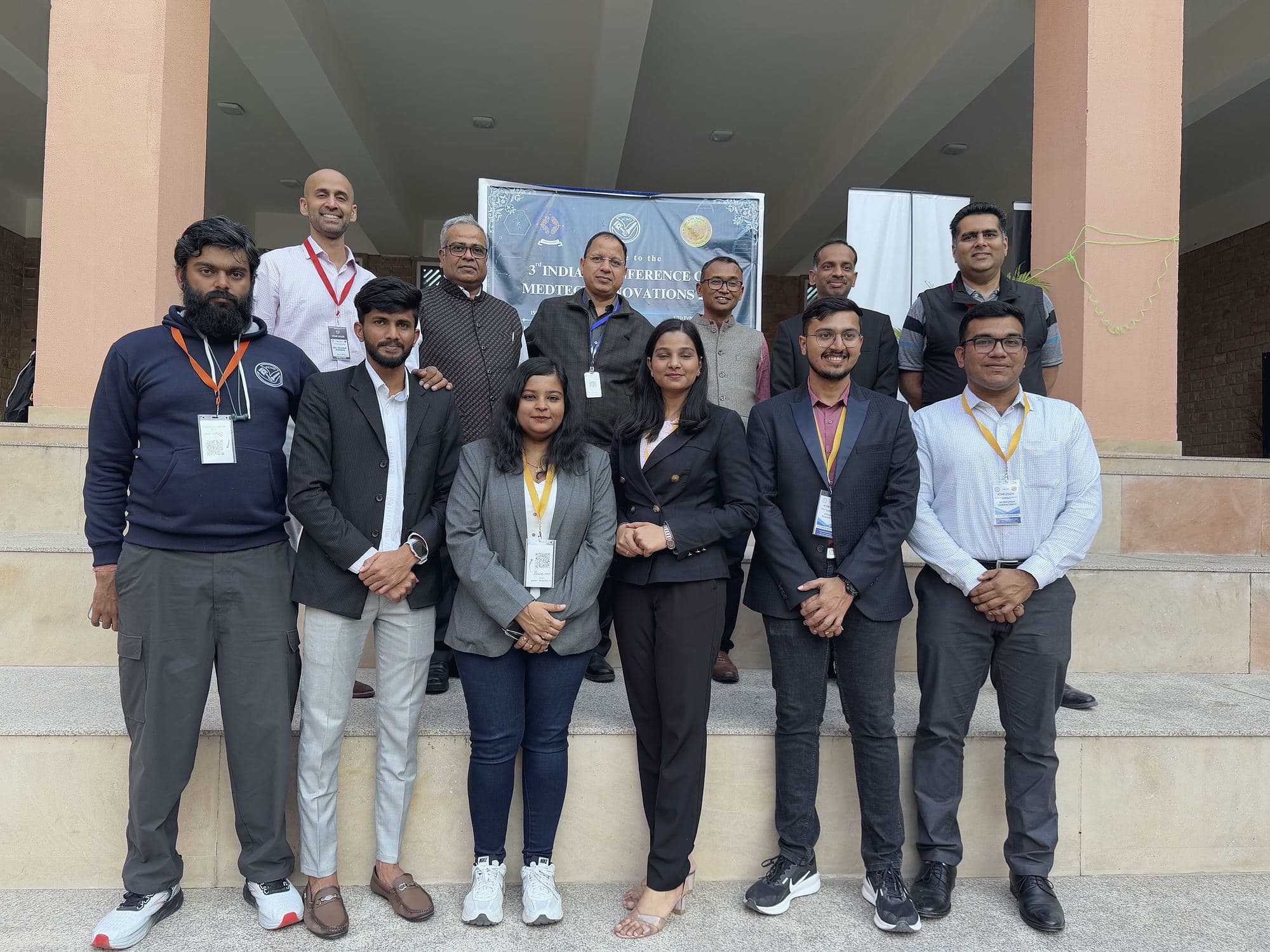 A group of conference participants standing together in formal attire